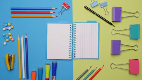 colorful pens and stationaries on blue and yellow surface