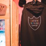 trendy hoodies and fridge with refreshing drinks in shop