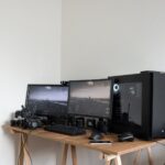 photographer desk with monitors and gadgets