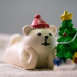 close up photo of white polar bear beside christmas tree figurines