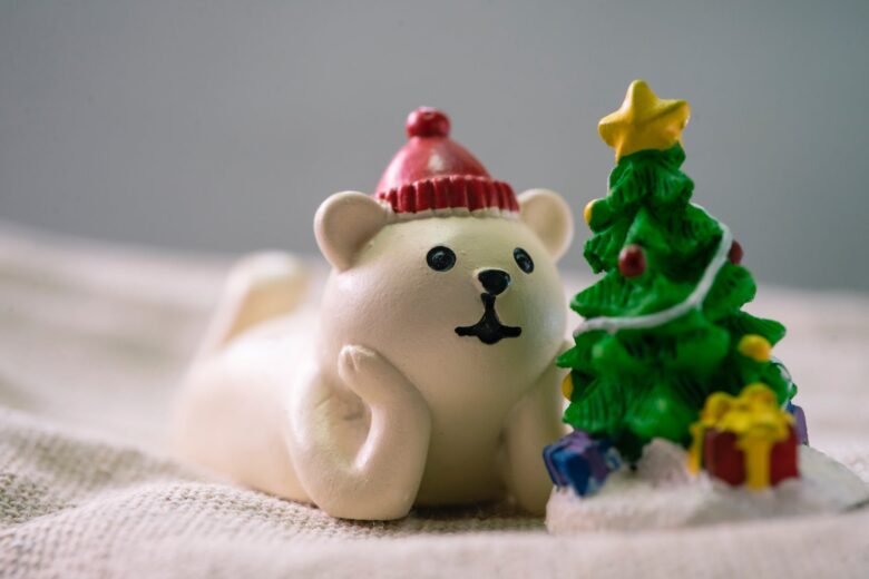 close up photo of white polar bear beside christmas tree figurines